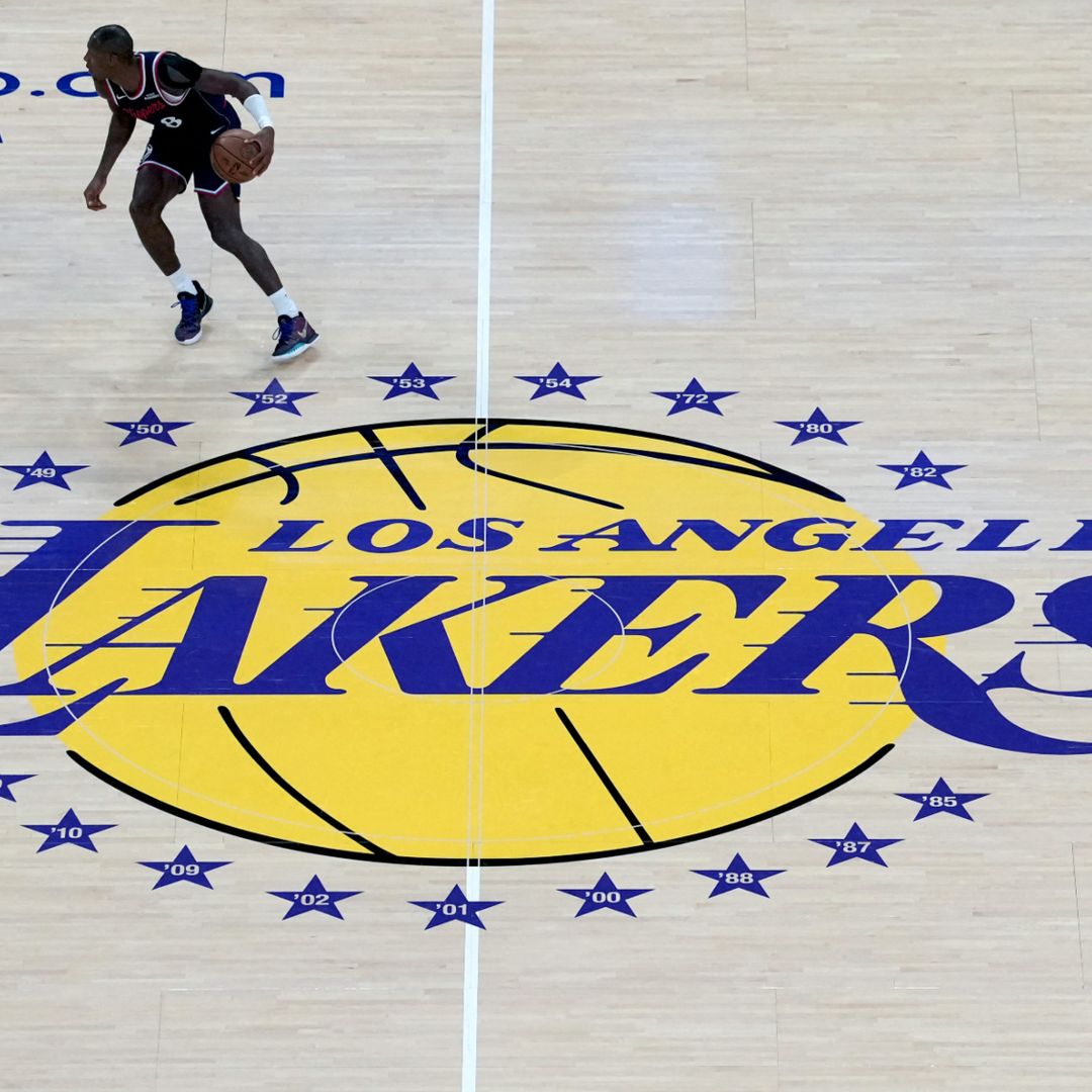Kris Dunn de los Clippers frente a Austin Reaves de Los Ángeles, sobre el logotipo de los Lakers.